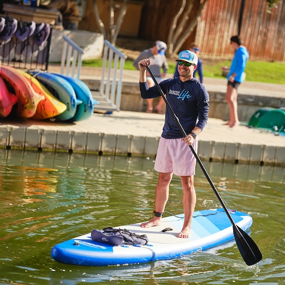 stand-up paddleboard on a lake, young man paddling