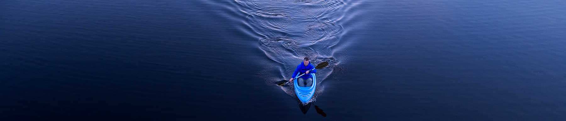 Hombre en kayak azul remando
