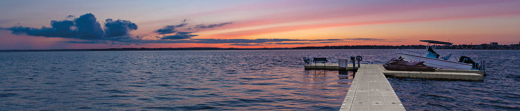 Dock view of sunset with parked motor boat