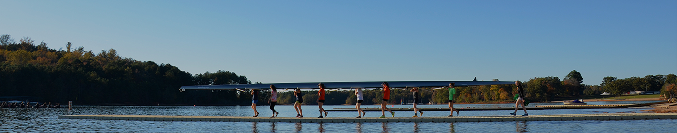 Un grupo de personas transporta una gran canoa por un muelle