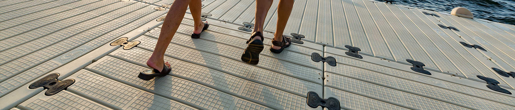 Pareja caminando en sandalias por el muelle flotante