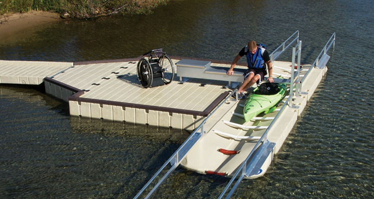 A man in a wheelchair transferring into a kayaking using an EZ Dock ADA accessible launch
