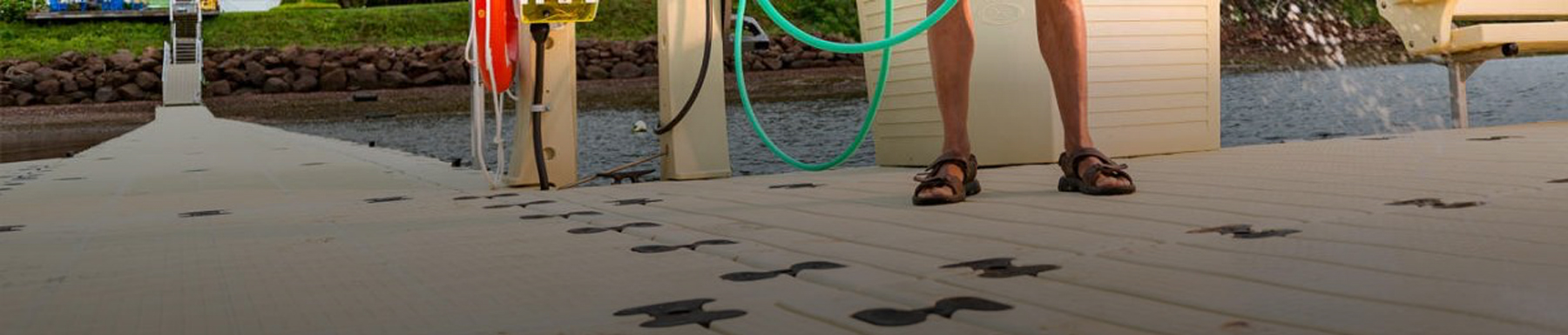Person wearing sandals holding hose on dock