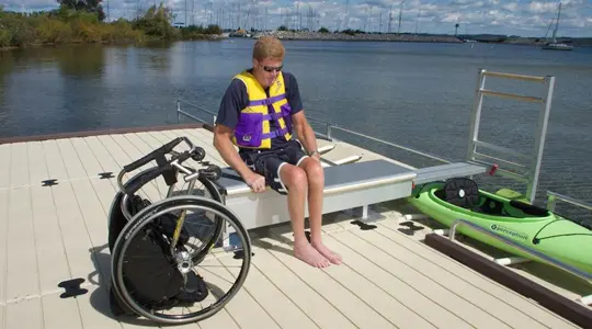 A handicapped man uses a motorized device to board his kayak