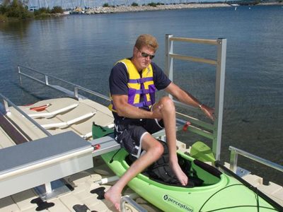 guy getting into kayak on launch area