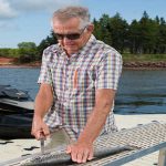 Man using fish cleaning station on dock