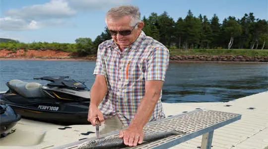 Man using fish cleaning station on dock