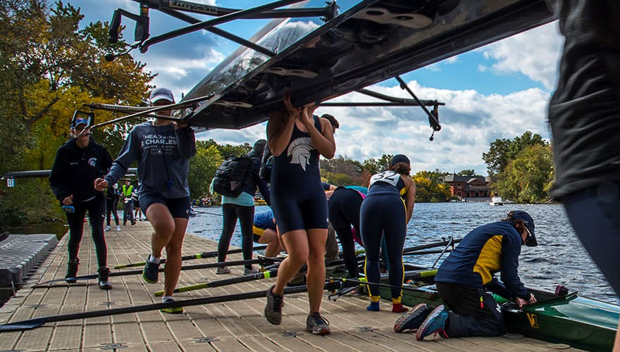 Rowing team lifting up shell