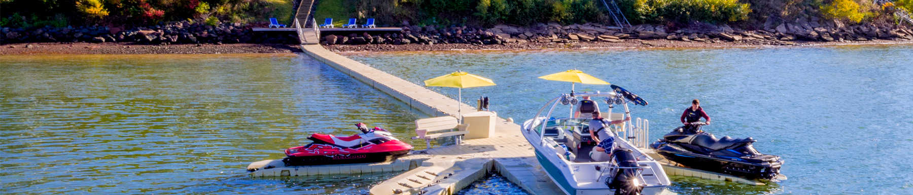 View of men launching motor boat and jet ski off shoreline