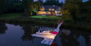Boat dock lit up in evening on lakeside property