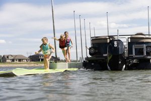 Kids walking on floating mat on top of water