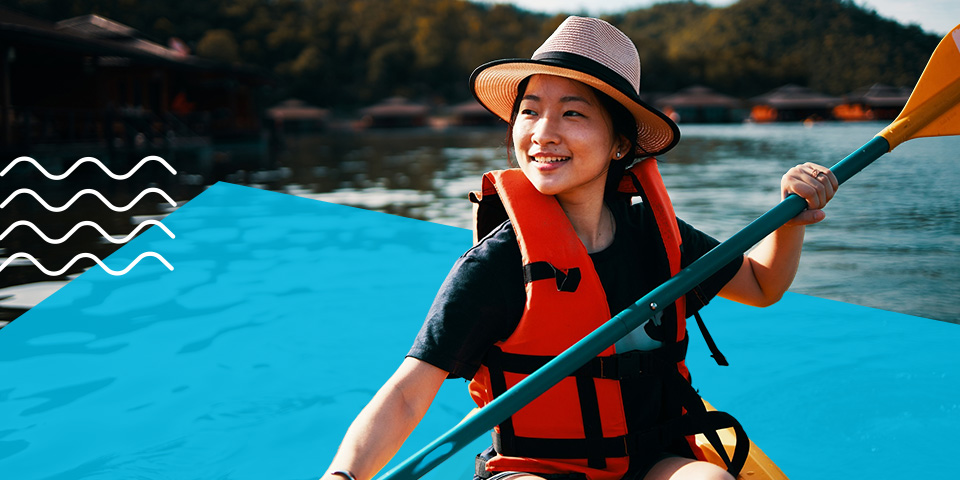 A woman happily paddles a kayak