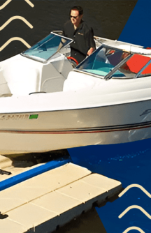 Man driving a white boat onto a mooring dock at a lake in Indiana