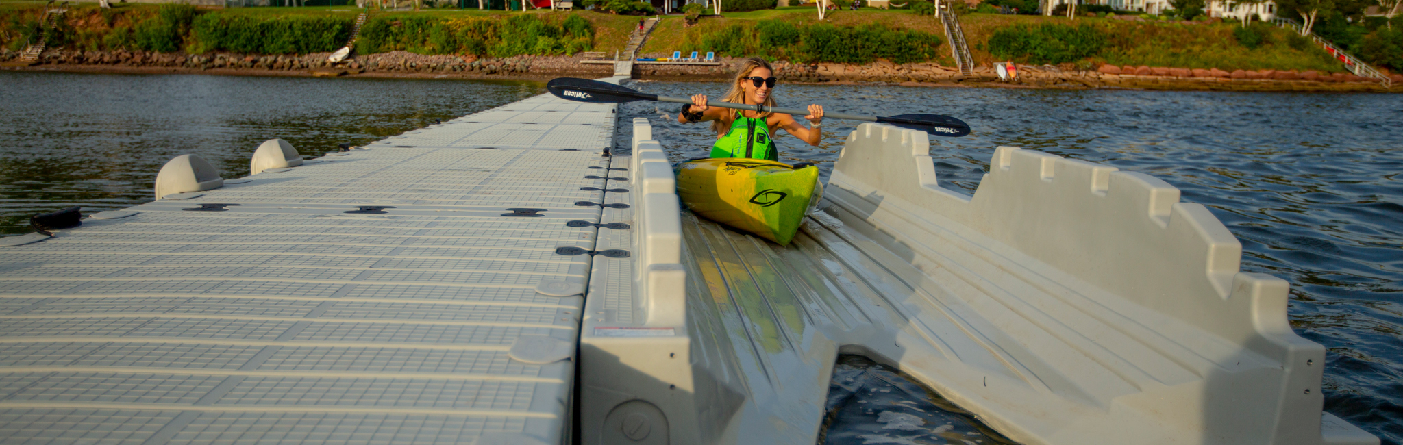 Woman bringing a kayak onto a launch