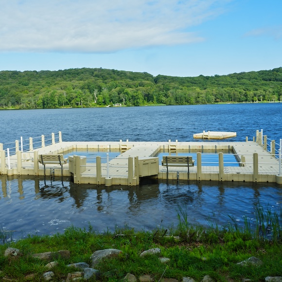 floating dock with two swim areas enclosed by dock sections, floating on a lake