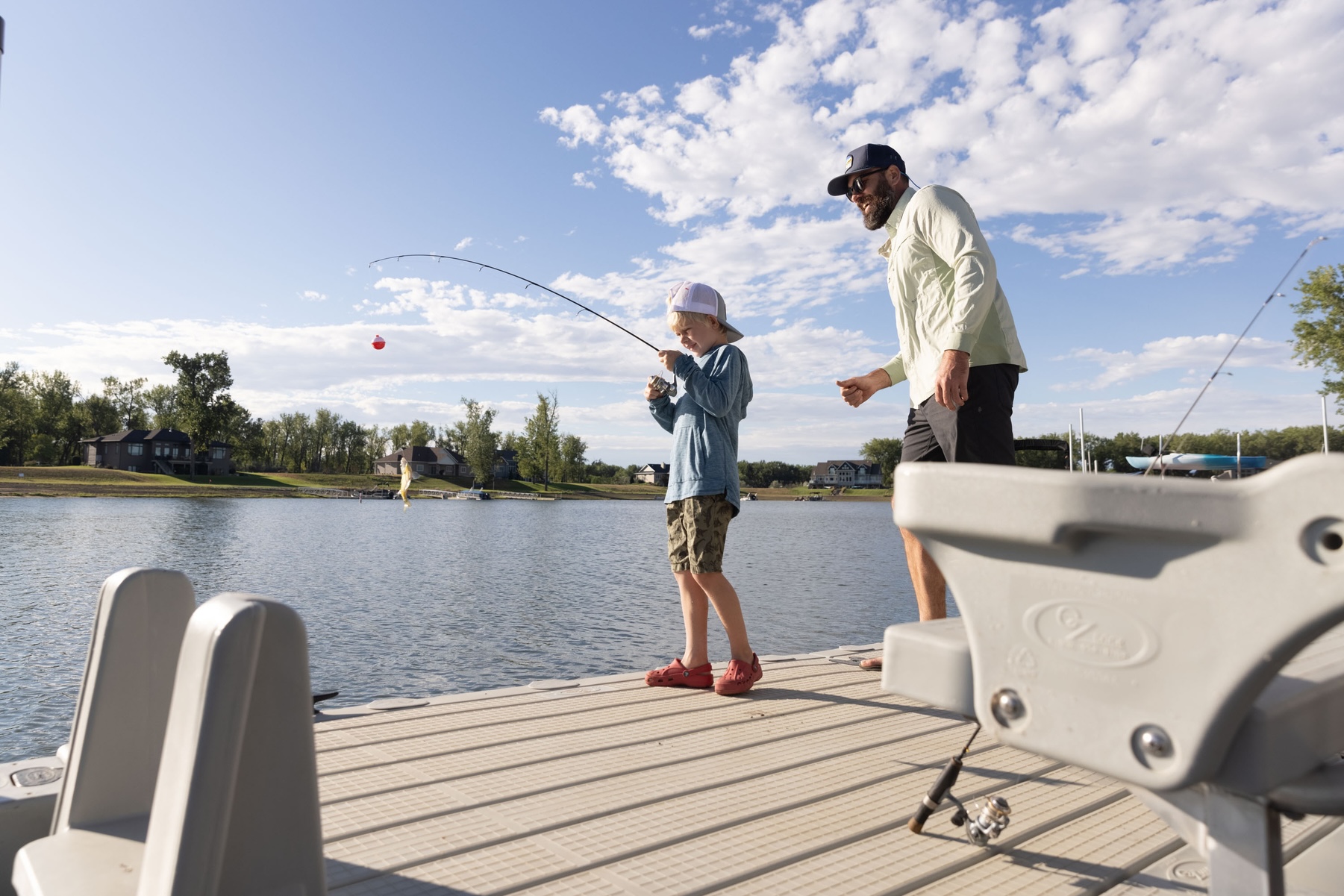 Un padre y su hijo pescando en un embarcadero flotante